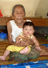 Foton ung och gammal - gammal kvinna med baby